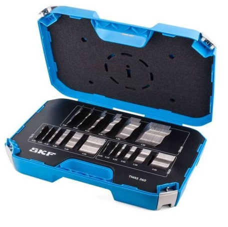 Obraz jest profesjonalną i kompleksową prezentacją produktu, ukazującą zestaw SKF TMAS 360 jako wszechstronne i niezbędne narzędzie dla każdego profesjonalnego działu utrzymania ruchu. Kompozycja jest czysta, zorganizowana i techniczna. Dominują w niej lśniące metaliczne odcienie stali nierdzewnej podkładek, kt&oacute;re kontrastują z ciemną, wytrzymałą walizką. Całość emanuje precyzją, wszechstronnością i gotowością do działania w r&oacute;żnych scenariuszach przemysłowych.  Pierwszy plan &ndash; Kompletne rozwiązanie do osiowania maszyn:  W centrum uwagi znajduje się solidna, otwarta walizka transportowa, kt&oacute;ra w pełni eksponuje bogate i uporządkowane wnętrze zestawu. Kluczowe elementy to:  Wytrzymała walizka: Ciemna, przemysłowa walizka z wyraźnie widocznym białym logo "SKF" oraz oznaczeniem modelu "TMAS 360". Jej otwarta forma zaprasza do zapoznania się z imponującą zawartością.  Wszechstronny zestaw 360 podkładek: Wnętrze walizki, wyłożone specjalnie wyprofilowaną pianką lub przegr&oacute;dkami, zawiera 360 podkładek precyzyjnych w trzech najpopularniejszych rozmiarach, co jest gł&oacute;wnym wyr&oacute;żnikiem tego zestawu:  50 x 50 mm: Do mniejszych maszyn i precyzyjnych regulacji.  75 x 75 mm: Uniwersalny rozmiar do większości standardowych silnik&oacute;w i pomp.  100 x 100 mm: Do większych maszyn przemysłowych.  Perfekcyjna organizacja: Każdy rozmiar podkładki ma swoją dedykowaną, wyraźnie oznaczoną sekcję, a w niej poszczeg&oacute;lne stosy są uporządkowane według sześciu kluczowych grubości (0.05, 0.10, 0.25, 0.50, 1.00, 2.00 mm). Taki układ wizualnie komunikuje łatwość i szybkość doboru odpowiedniej podkładki w każdych warunkach.  Najwyższa jakość wykonania: Podkładki, wykonane z wysokogatunkowej stali nierdzewnej, lśnią w studyjnym oświetleniu. Na każdej z nich widoczne jest precyzyjne, laserowo grawerowane oznaczenie grubości i wymiaru, co eliminuje pomyłki. Charakterystyczne wycięcie ułatwiające montaż jest dobrze widoczne na każdym stosie.  Tło i branding:  Tło jest neutralne (np. białe lub jasnoszare), aby nie odwracać uwagi od bogactwa zestawu. Gł&oacute;wne elementy brandingowe to logo SKF na walizce oraz oznaczenia na samych podkładkach, co jest gwarancją autentyczności i najwyższej jakości.  Przesłanie i hasło reklamowe (optymalizacja SEO):  Obraz niesie jasny komunikat o wszechstronności, precyzji i profesjonalizmie. Skierowany jest do technik&oacute;w utrzymania ruchu, firm serwisowych i inżynier&oacute;w, kt&oacute;rzy potrzebują jednego, kompletnego zestawu do osiowania maszyn o r&oacute;żnych gabarytach, pokrywającego większość standardowych zastosowań przemysłowych.  Całość może być wzmocniona hasłem, kt&oacute;re zawiera kluczowe frazy:  "Jeden zestaw do wszystkich zadań. Uniwersalne podkładki do osiowania SKF TMAS 360."  "Wszechstronność i precyzja w jednej walizce. SKF TMAS 360 dla profesjonalist&oacute;w."  "Twoje kompletne rozwiązanie do osiowania maszyn &ndash; Zestaw SKF TMAS 360."