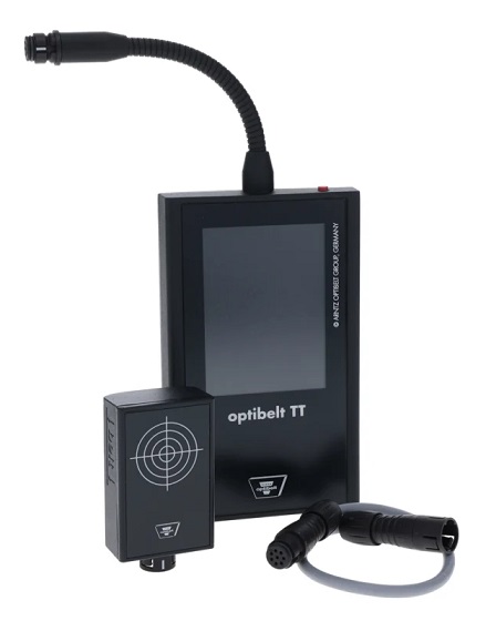 OPTI-TT TT OPTIBELT | DAKAM Na zdjęciu widoczne jest niewielkie, przenośne urządzenie z cyfrowym wyświetlaczem. Miernik jest w szaro-czerwonej obudowie, która jest ergonomiczna i wygodna w trzymaniu. Na górnej części urządzenia znajduje się mikrofon, który służy do pomiaru częstotliwości drgań pasa. Poniżej znajduje się wyświetlacz LCD, na którym wyświetlane są wyniki pomiarów w hercach (Hz) oraz inne komunikaty. Obok wyświetlacza widać przyciski do obsługi urządzenia, takie jak włącznik, czy przyciski do nawigacji po menu. Na obudowie urządzenia, tuż pod wyświetlaczem, wyraźnie widoczne jest logo producenta, OPTIBELT, oraz nazwa modelu, OPTI-TT TT. Zdjęcie może przedstawiać miernik w dłoni, co podkreśla jego mobilność, lub położony na stole, gotowy do użycia.