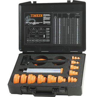 Obraz jest ucieleśnieniem amerykańskiej inżynierii i profesjonalizmu w dziedzinie utrzymania ruchu, kt&oacute;re są synonimami marki TIMKEN. Kompozycja łączy w sobie solidny, techniczny wizerunek kompletnego zestawu narzędzi do montażu na zimno z zaufaniem i dostępnością, jakie budzi autoryzowany polski dystrybutor DAKAM. Dominują w niej charakterystyczne dla TIMKEN barwy &ndash; głęboka czerń i czerwień &ndash; oraz przemysłowe odcienie stali i twardego tworzywa. W centrum uwagi, na czystej, industrialnej powierzchni (np. metalowym stole warsztatowym lub białym tle), znajduje się otwarta, solidna walizka transportowa zawierająca kompletny zestaw montażowy TIMKEN: &bull;	Profesjonalna walizka: Wytrzymała walizka w charakterystycznym czarnym lub czerwonym kolorze z wyraźnym logo "TIMKEN". Jej wnętrze jest wyprofilowane (np. piankowa wytłoczka), idealnie dopasowane do wszystkich element&oacute;w zestawu, co podkreśla porządek i profesjonalizm. &bull;	Pierścienie udarowe: Widoczny jest komplet precyzyjnych pierścieni udarowych (zazwyczaj czarnych, wykonanych z twardego, odpornego na uderzenia tworzywa). Są one starannie ułożone w walizce. Ujęcie makro może eksponować wyraźne oznaczenia rozmiar&oacute;w na każdym pierścieniu, co podkreśla łatwość doboru. &bull;	Tuleje udarowe: Zestaw solidnych, aluminiowych lub stalowych tulei o r&oacute;żnych długościach, służących do bezpiecznego przeniesienia siły. &bull;	Młotek bezodrzutowy: W zestawie znajduje się r&oacute;wnież charakterystyczny młotek bezodrzutowy (dead-blow hammer), często z czerwono-czarną rękojeścią, kt&oacute;ry wizualnie komunikuje metodę pracy &ndash; precyzyjne uderzanie bez ryzyka uszkodzenia komponent&oacute;w. &bull;	Wizualne przesłanie: Cały zestaw wizualnie komunikuje kluczową zasadę prawidłowego montażu &ndash; r&oacute;wnomierne przykładanie siły tylko do właściwego pierścienia łożyska, aby uniknąć uszkodzenia element&oacute;w tocznych. Tło jest subtelnie rozmyte (efekt bokeh), ale jednoznacznie wskazuje na profesjonalną dystrybucję na terenie Polski: &bull;	Nowoczesny magazyn DAKAM: W tle widać rzędy wysokich regał&oacute;w magazynowych, wypełnionych uporządkowanymi, oryginalnymi, czerwono-czarnymi opakowaniami TIMKEN. Duża ilość towaru na stanie wizualnie potwierdza status "sprawdzonego dystrybutora". &bull;	Logo Dystrybutora: W dyskretnym, ale widocznym miejscu umieszczone jest logo DAKAM, z dopiskiem "Autoryzowany Dystrybutor TIMKEN" lub "Centrum Utrzymania Ruchu", co buduje jego markę jako zaufanego partnera w dostawach narzędzi diagnostycznych. Obraz niesie jasny komunikat: "Jako autoryzowany polski dystrybutor DAKAM, posiadamy na stanie profesjonalne, amerykańskie zestawy do montażu łożysk na zimno TIMKEN, niezbędne do zapewnienia bezpiecznego i bezuszkodzeniowego montażu w utrzymaniu ruchu".