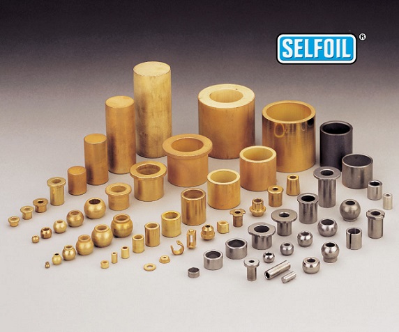 Zdjęcie przedstawia precyzyjnie wykonane tulejki AMES, ułożone w estetycznej, inżynieryjnej kompozycji na ciemnym tle, co podkreśla ich kształt i kolor.  Na pierwszym planie znajduje się kilka tulejek, starannie rozłożonych, aby pokazać ich r&oacute;żnorodne rozmiary i typy &ndash; od małych, cienkościennych element&oacute;w po większe, bardziej masywne. Mają one charakterystyczny, jednolity, matowy metaliczny odcień, prawdopodobnie brązu spiekanego, kt&oacute;ry jest typowy dla produkt&oacute;w samosmarujących.  Powierzchnia tulejek jest gładka i pozbawiona jakichkolwiek skaz, co świadczy o wysokiej jakości produkcji. Na jednej z tulejek widoczne jest subtelne oznaczenie lub logo AMES, potwierdzające jej pochodzenie.  Oświetlenie jest skierowane na detale, tworząc delikatne cienie, kt&oacute;re uwypuklają tr&oacute;jwymiarowość obiekt&oacute;w. Całość zdjęcia ma profesjonalny charakter, jak z katalogu technicznego, i kładzie nacisk na precyzję, trwałość i niezawodność, będące kluczowymi cechami tulejek spiekanych AMES.